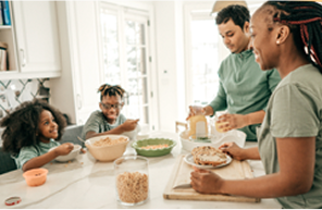 Family of four having breakfeast at kitchen table